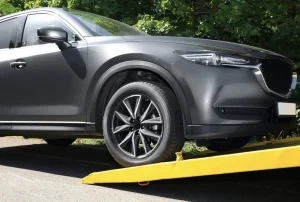 suv being loaded onto a tilt deck tow truck front